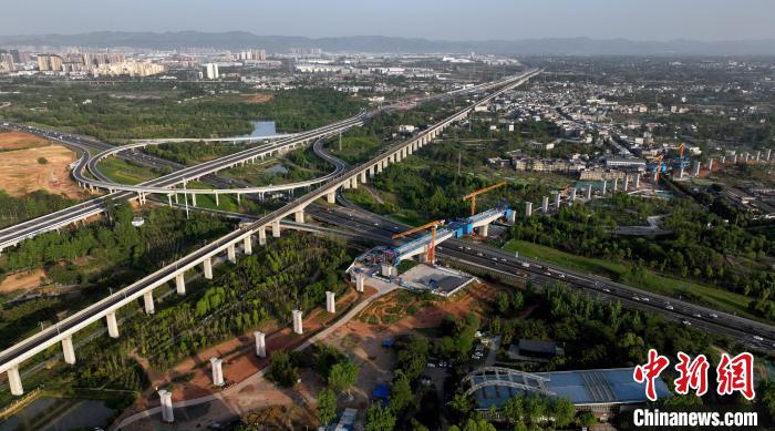 航拍正在建設(shè)的跨越成都繞城高速公路連續(xù)梁施工現(xiàn)場，旁邊依次為已運(yùn)營的成渝高速鐵路和機(jī)場高速公路。　劉忠俊 攝