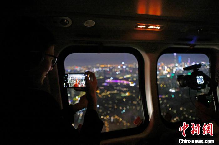 6月3日晚，游客乘坐上海新空直升機有限公司直升機開啟鳥瞰黃浦江空中圓夢之旅，并用手機拍攝城市夜景?！∫罅⑶?攝