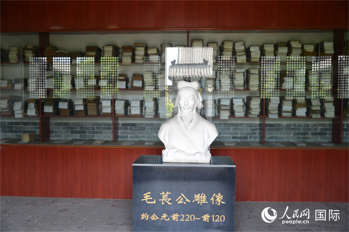 河間詩(shī)經(jīng)齋毛萇雕像。雕像后書(shū)櫥中陳列的是歷代各版本《詩(shī)經(jīng)》及譯本。 人民網(wǎng) 趙昭攝