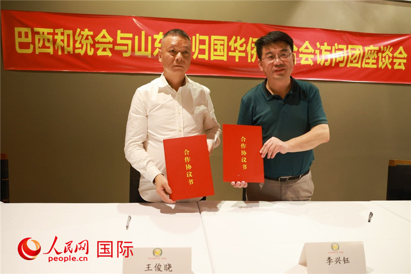 中國僑聯副主席、山東省僑聯主席李興鈺（右）與巴西和統會會長王俊曉簽署合作協議書。人民網記者 陳海琪攝