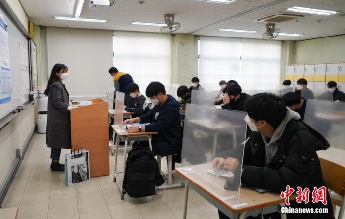 12月3日，延遲近一個(gè)月的韓國(guó)高考舉行。據(jù)韓國(guó)教育部消息，今年考生約49.34萬(wàn)人，創(chuàng)歷史最低紀(jì)錄。圖為在首爾某考點(diǎn)內(nèi)，考桌上設(shè)有隔板。