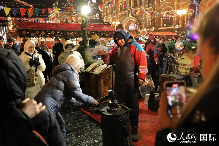 游客在新年集市上體驗制作紀念幣。人民網記者 隋鑫攝