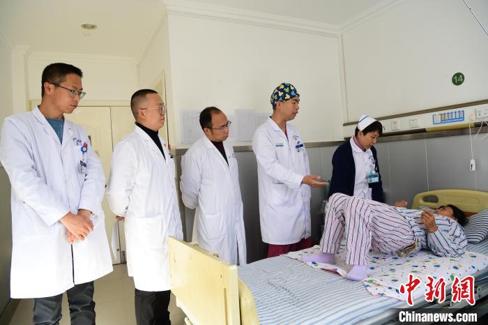 圖為何蔚副主任醫師(站右二)及團隊術后指導患者進行腰背肌鍛煉。　貢嘎來松 攝