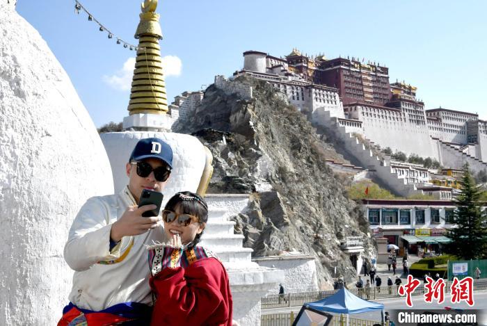4月17日，游客身著藏式元素服裝在拉薩布達拉宮觀景臺拍照留念?！±盍?攝