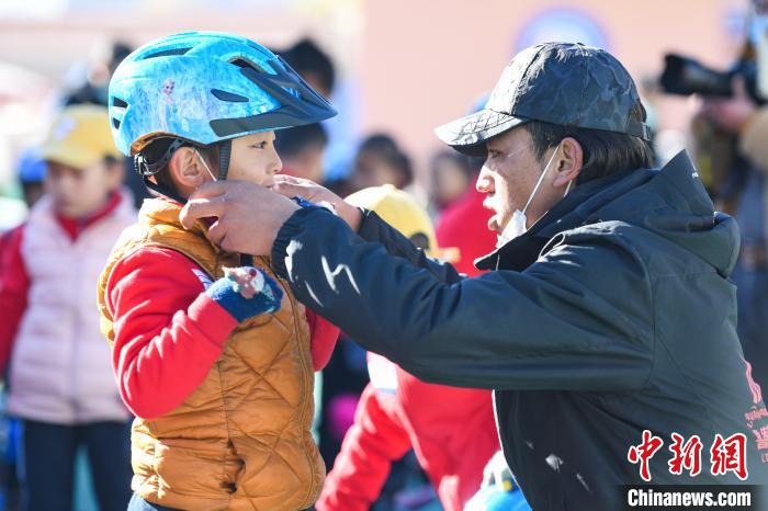 圖為拉薩市實(shí)驗(yàn)幼兒園孩子在教練的幫助下穿戴頭盔。　何蓬磊 攝