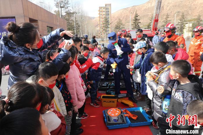 圖為小朋友們聽(tīng)消防員講解消防器材。　楊龍建 攝