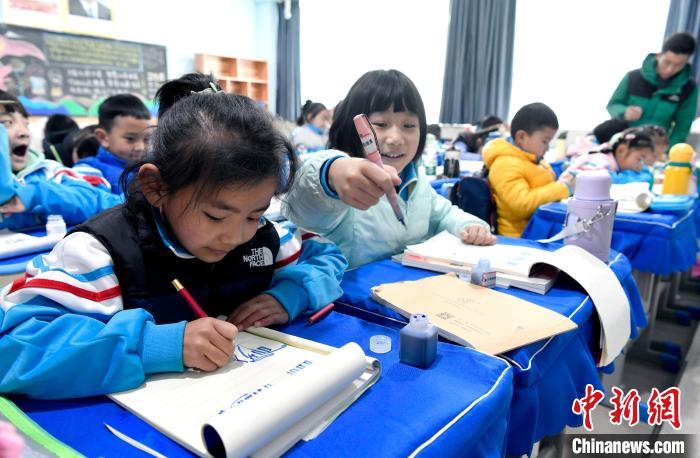 3月14日，西藏拉薩市第一小學(xué)一年級(jí)六班學(xué)生白瑪朗珍(圖左)在藏語(yǔ)文課上書(shū)寫(xiě)藏文。　李林 攝