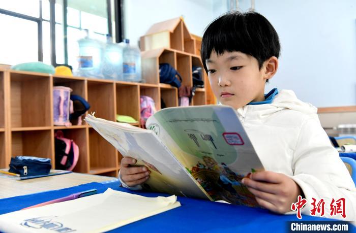 3月14日，西藏拉薩市第一小學(xué)一年級(jí)六班學(xué)生丁增樂(lè)吉在閱讀藏語(yǔ)課本。　李林 攝