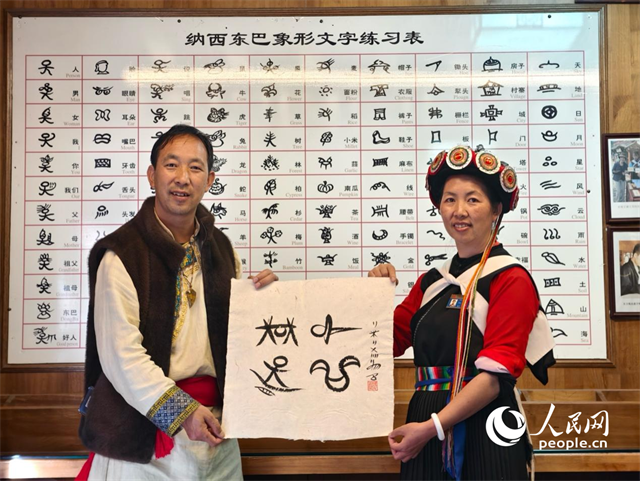 人民網“行進中國”云南調研采訪團走進麗江，和閏元現場用東巴文寫下“行進中國”。人民網記者 符皓攝