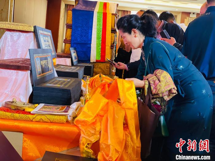 圖為現(xiàn)場藏族民眾向黃金書寫的大藏經(jīng)《甘珠爾》敬獻哈達。　孫睿 攝