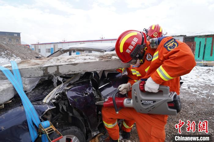 圖為地震實戰(zhàn)拉動現(xiàn)場，參演人員進(jìn)行車輛破拆。　玉樹消防供圖