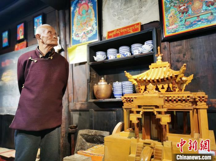 圖為古堡內的藝人桑杰展示自己的雕刻作品。　張?zhí)砀?攝