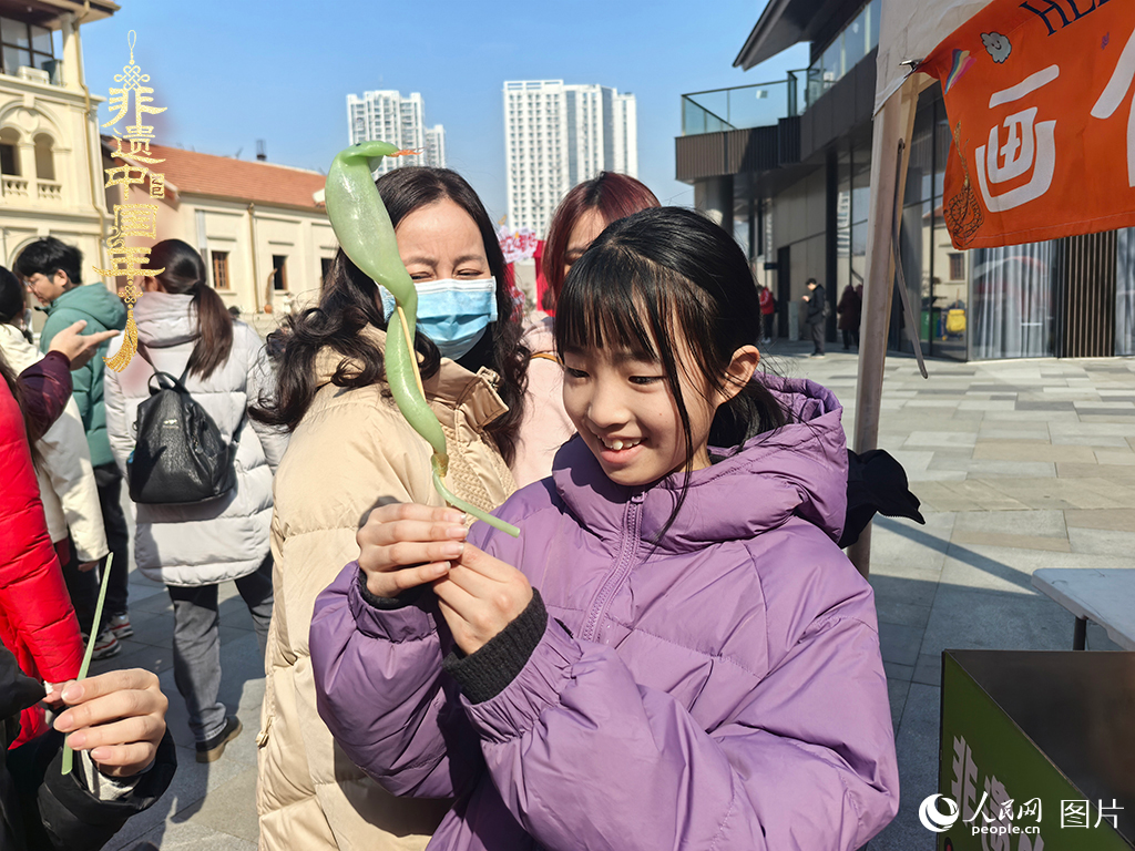 2025年1月29日，湖北武漢的新春廟會上，小朋友拿著吹制好的糖人，十分開心。人民網記者 張沛攝