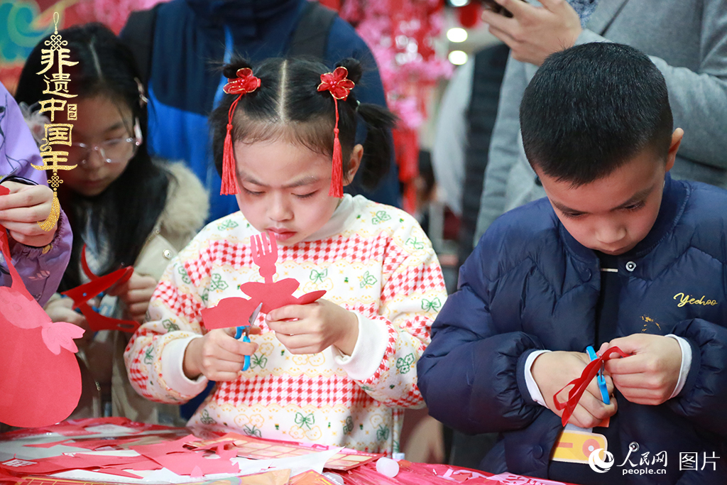 2025年1月23日，上海市青少年活動中心迎新春游園會上，小朋友們正在學習剪窗花。人民網記者 龔莎攝