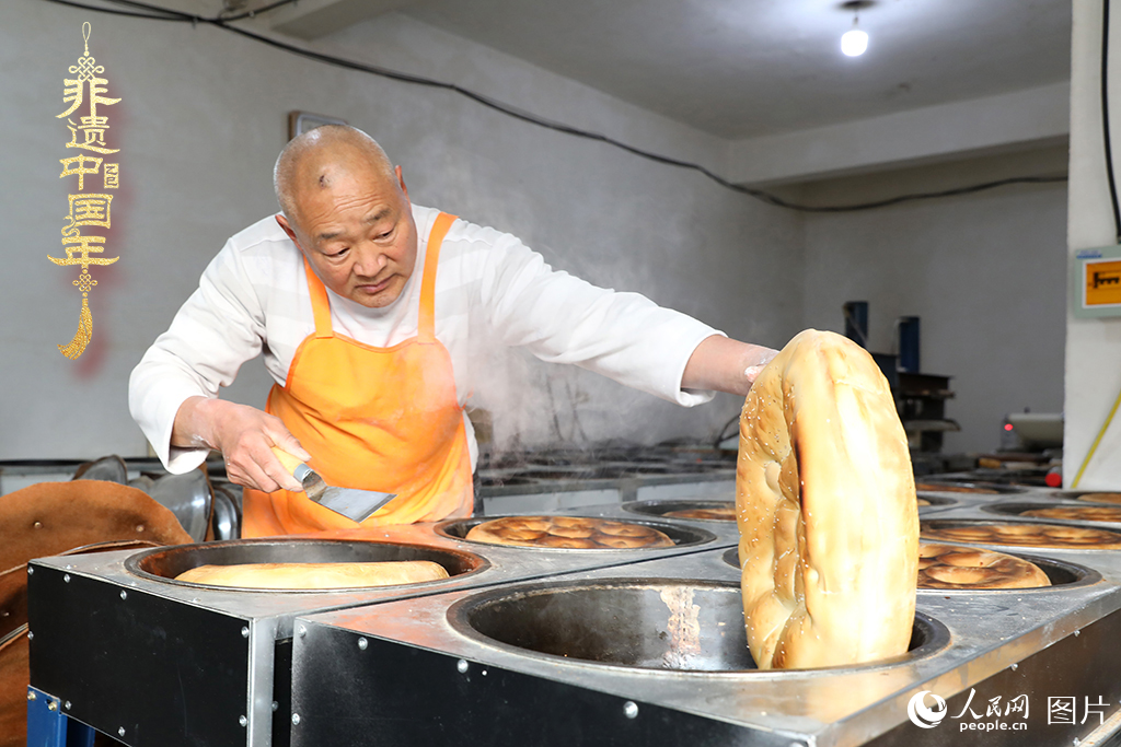 2025年1月23日，山東省臨沂市莒南縣一家傳統大餅作坊內，師傅們正忙著烤制當地人春節期間家家戶戶必備的、金黃誘人的莒南大餅。人民網記者 劉祺攝